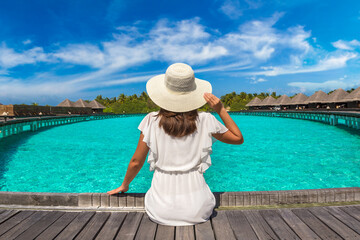 Fototapeta premium Woman sitting on the wooden pier