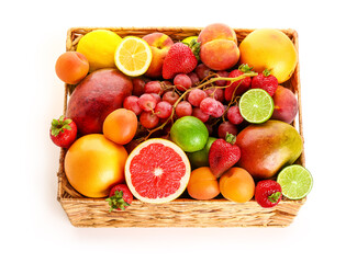 Wicker basket with different fresh fruits on white background