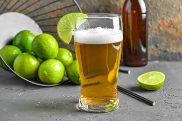 Glass of cold beer with lime on table
