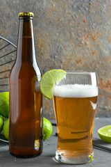 Glass of cold beer with lime on table