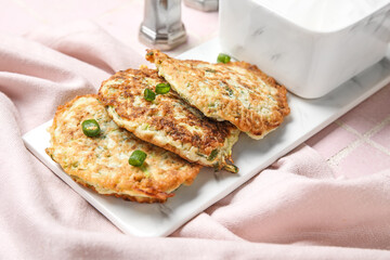 Board of tasty zucchini fritters on table