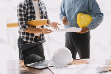 Fototapeta premium Construction and structure concept of engineer working drawing on blueprint meeting for project working with partner on model building and engineering tools in working site, construction concept.