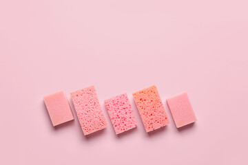 Row of different sponges on pink background