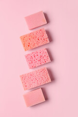Row of different sponges on pink background