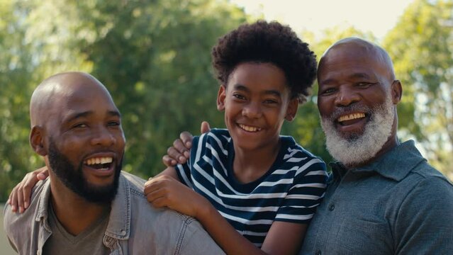 Portrait of loving multi-generation male family outdoors in garden at home or in countryside - shot in slow motion