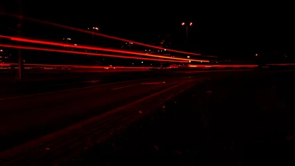 Photo sur Plexiglas Autoroute dans la nuit Lights of cars at night. Street line lights. Night highway city. Long exposure photograph night road. Colored bands of red light trails on the road. Background wallpaper defocused photo. 