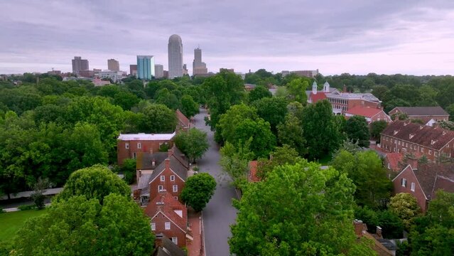 Aerial tilt up from Old Salem to Winston Salem NC, North Carolina