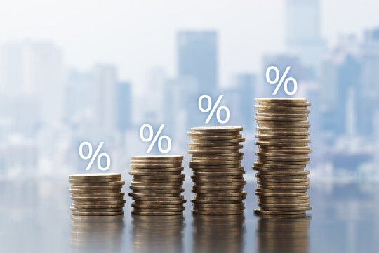 Interest, dividends or tax rates. Stacked money and percentage marks on cityscape background. Abstract image of finance and accounting.