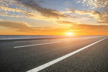 Naklejka premium Asphalt road and sky clouds at sunset