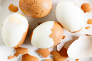 Boiled eggs with brown shall on white plate.