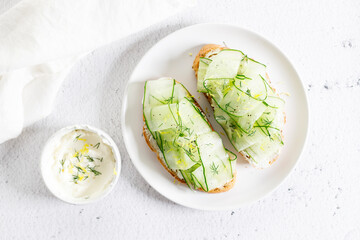 Breakfast bread sandwiches with sliced cucumber and cream cheese.