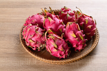 Red dragon fruit or pitaya in basket on wooden background, Tropical fruit in summer season