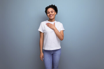charming owner of curly hair woman dressed in a white t-shirt on an isolated background with copy space