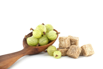 Gooseberries and brown cane sugar cubes on white