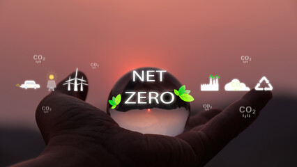 Environment concept. Hand holding glass ball with zet zero icon against morning . environmental icons. Global warming. Sustainable development. Solar , Green Business Future Sustainability Net Zero. - obrazy, fototapety, plakaty