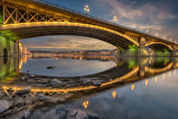 Fototapeta na wymiar Illuminated Margaret Bridge Reflected on The Surface of The Danube at Sunset. Budapest, Hungary.