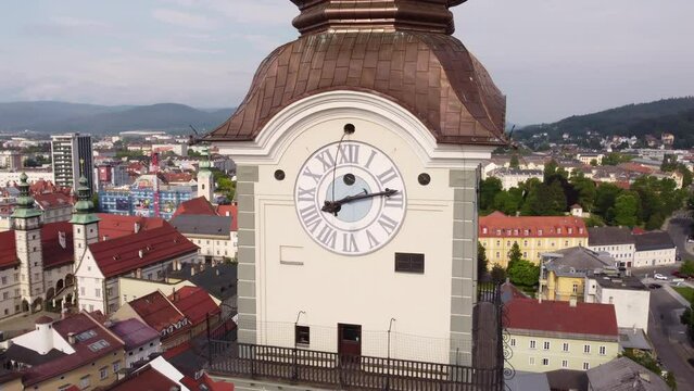 Aerial orbit around clock tower of quaint Chapel in Klagenfurt, Austria