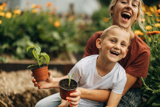 Joyful mother and son having fun in the arden. - Powered by Adobe