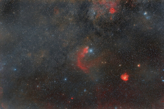 Photo of outer space. soft focus. Lots of small stars all over the frame. foggy objects. Red nebulae in the constellation Cassiopeia.