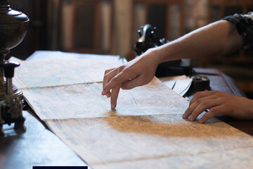 person's finger pointing on the old map to go to the destination