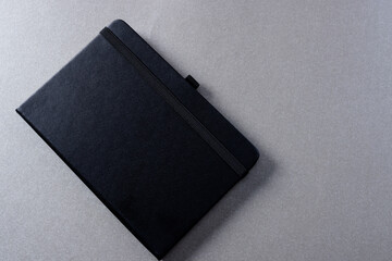 Close up of black notebook with copy space on grey background
