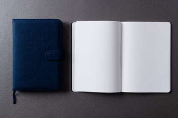 Close up of blue notebook and open book with copy space on grey background