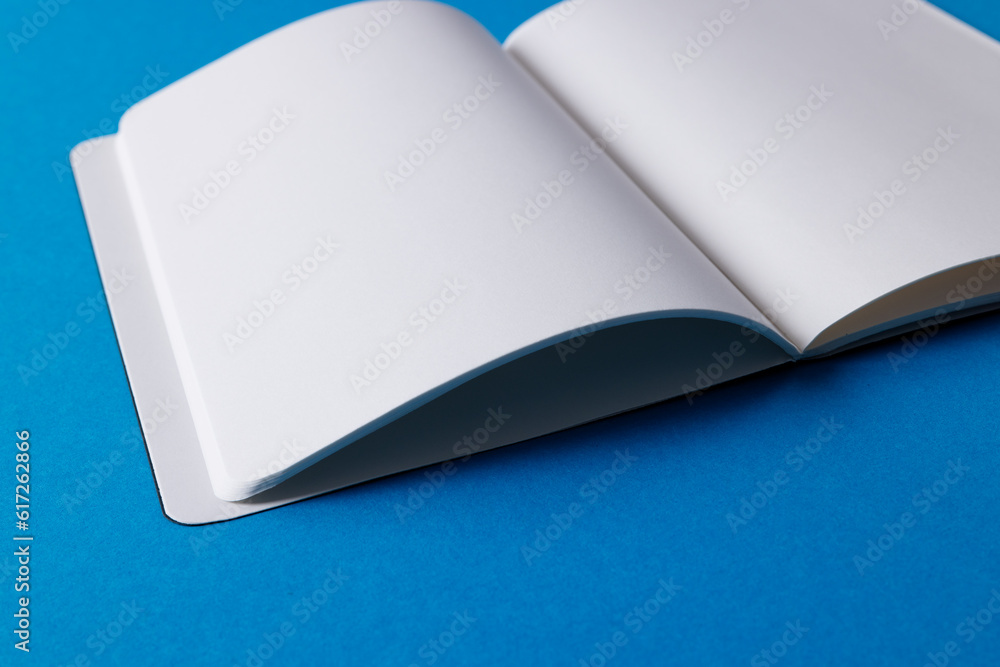 Poster close up of open book with copy space on blue background