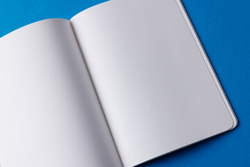 Close up of open book with copy space on blue background