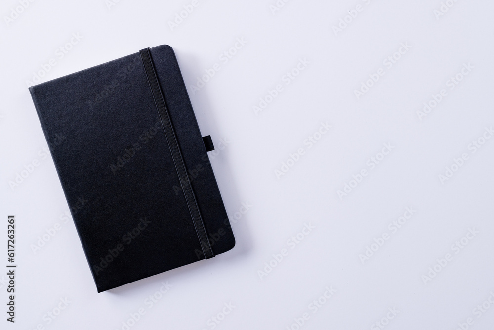 Poster close up of black notebook with copy space on white background