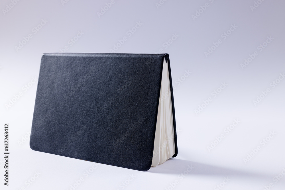 Poster close up of black notebook with copy space on white background
