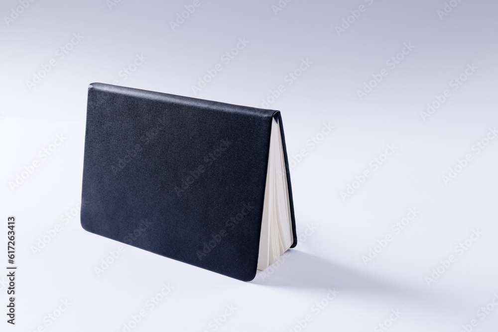 Poster close up of black notebook with copy space on white background