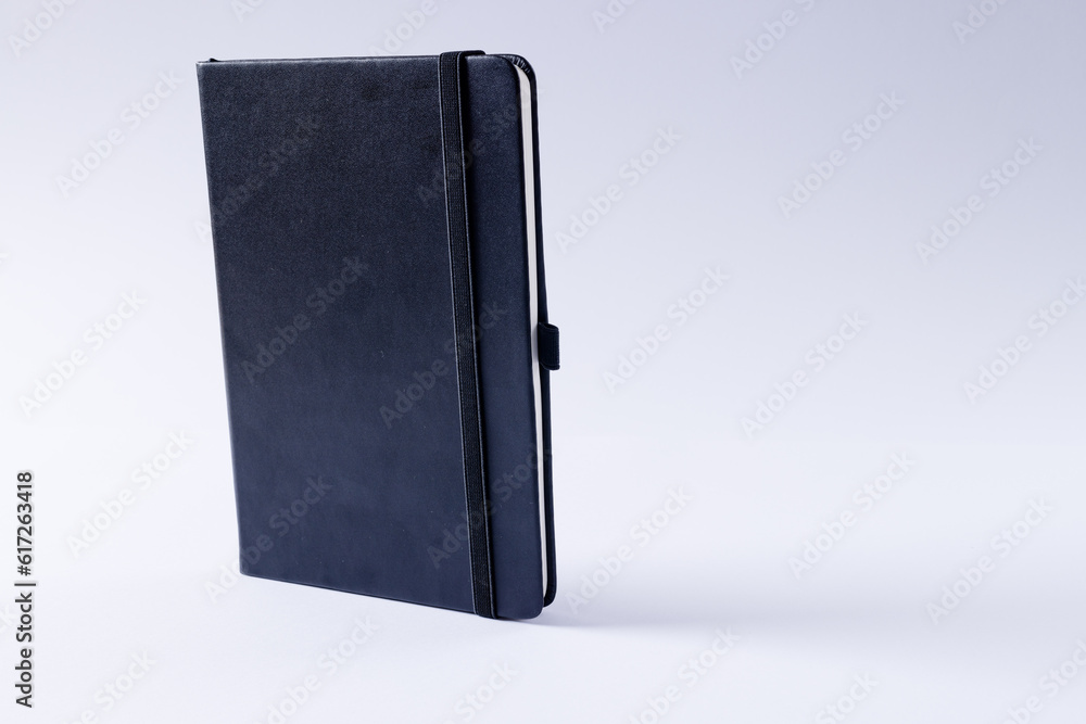 Poster close up of black notebook with copy space on white background