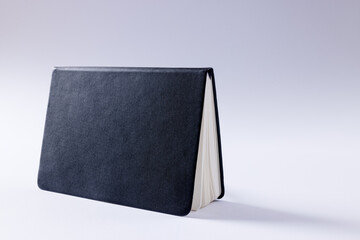 Close up of black notebook with copy space on white background