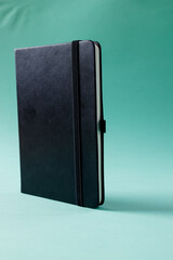 Close up of black notebook with copy space on green background