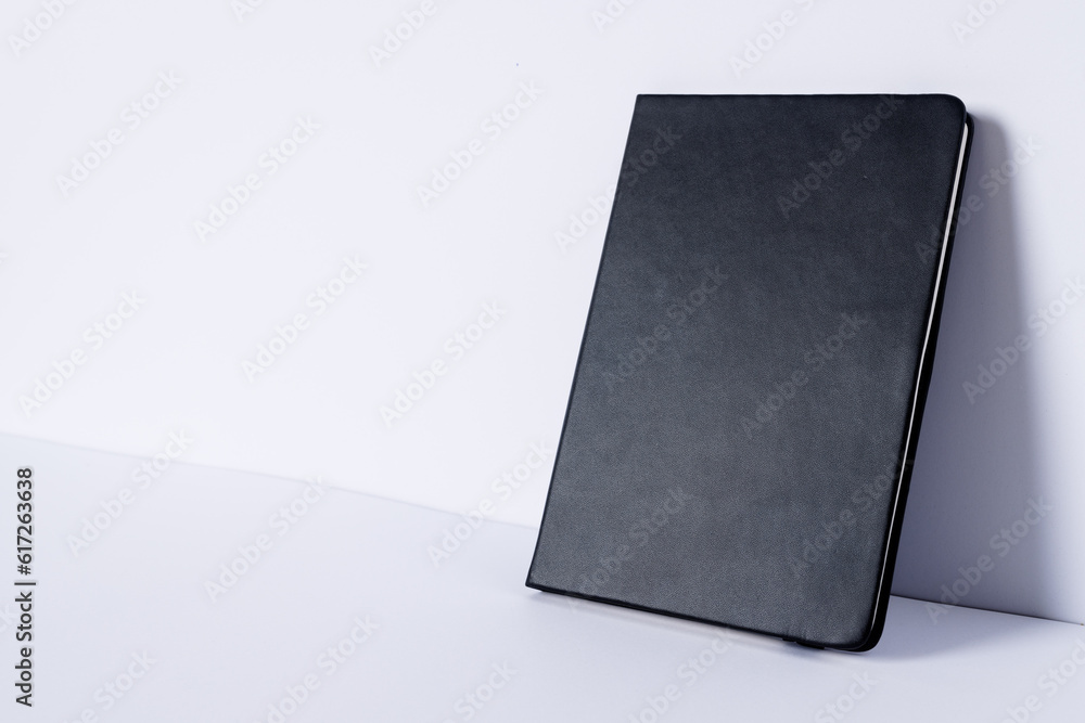 Poster close up of black notebook with copy space on white background