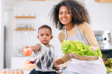 African black mother with cute son child portrait happy enjoy healthy food cooking at home kitchen...