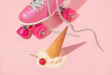 Summer creative layout with pink roller skates and ice cream cone up side down and vanilla ice cream scoop with bright red cherry on pastel pink background. 80s or 90s retro aesthetic fashion idea.