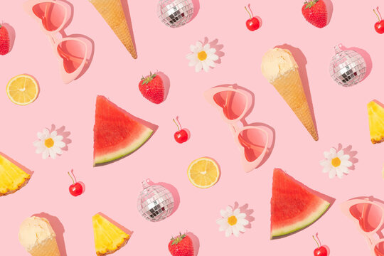 Summer creative pattern made with heart sunglasses, ice cream, watermelon, pineapple, strawberry, cherry, lemon slice, white flower, disco ball on pastel pink background. 80s or 90s retro aesthetic 