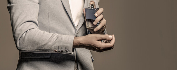 Masculine perfume, bearded man in a suit. Male holding up bottle of perfume. Man perfume, fragrance