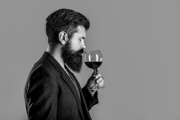 Sommelier, degustator with glass of wine, winery, male winemaker. Man with a glass of red wine in his hands. Man sommelier tasting red wine. Black and white
