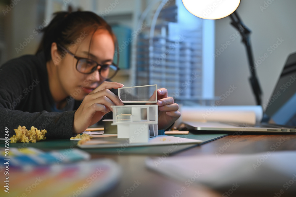 Poster architecture students diligently make house model building samples with paper architecture and tools
