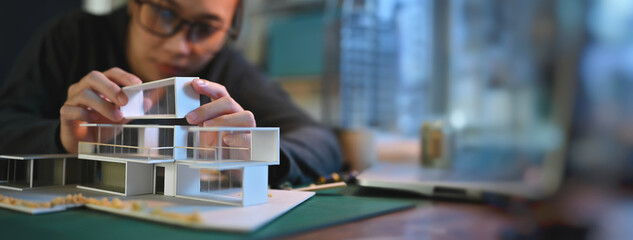 Architecture students diligently make house model building samples with paper architecture and...