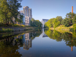 City park with a lake. In the background is a new building.