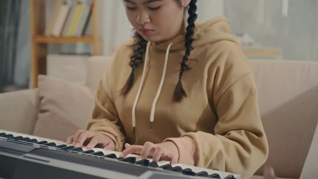 Teacher thumping rhythm while student playing electronic piano during music class