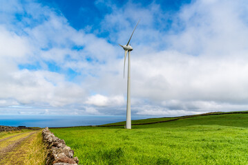 Fototapeta na wymiar Panoramic view of wind farm or wind park, with high wind turbines for generation electricity with copy space. Green energy concept. Terceira Island, Azores, Portugal