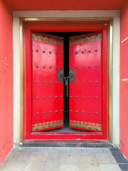 old Chinese wooden door with red wall