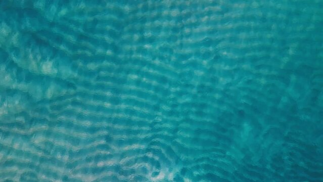 Aerial view of the sandy beach covered with thin layer of water. Sea surface aerial view.
