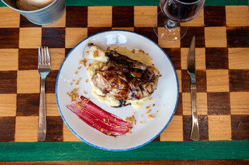 Table setting with wine, food, and glass on kitchen counter.