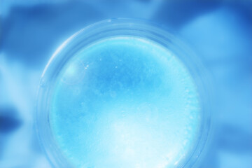 Abstract Defocus blue tiny water bubble in transparent plastic cup. Abstract premium blue backdrop banner for advertise commercial, cosmetic skincare and consumers products.