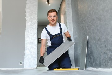 industrial worker, handyman installing ceramic tiles.